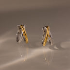 Two intertwined hoops in silver and gold tones form the sculptural Laced Mixed Metal Huggies, creating a modern crossover design. Discover versatile elegance—these gold and silver earrings are perfect for any occasion.