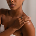 A woman rests her hand on her shoulder, showcasing the Skinny Agate Ring—an ideal pick for gemstone lovers enchanted by its elegant green marbling.