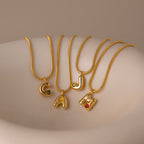 The Gemstone Bubble Initial Necklace features gold letter pendants C, A, J, and M, each accented with colorful gemstones—an ideal choice for anyone seeking personalized jewelry.