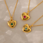 Three North Star Birthstone Heart Necklaces—each with a red, green, or blue gemstone—create a charming display of personalized jewelry on a light background.