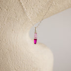 The Toi et Moi Tapered Birthstone Necklace features a delicate baguette-cut pendant with a striking pink gemstone.