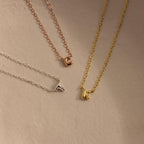 Rose gold letter C, silver letter T and gold letter K bubble initial necklaces.