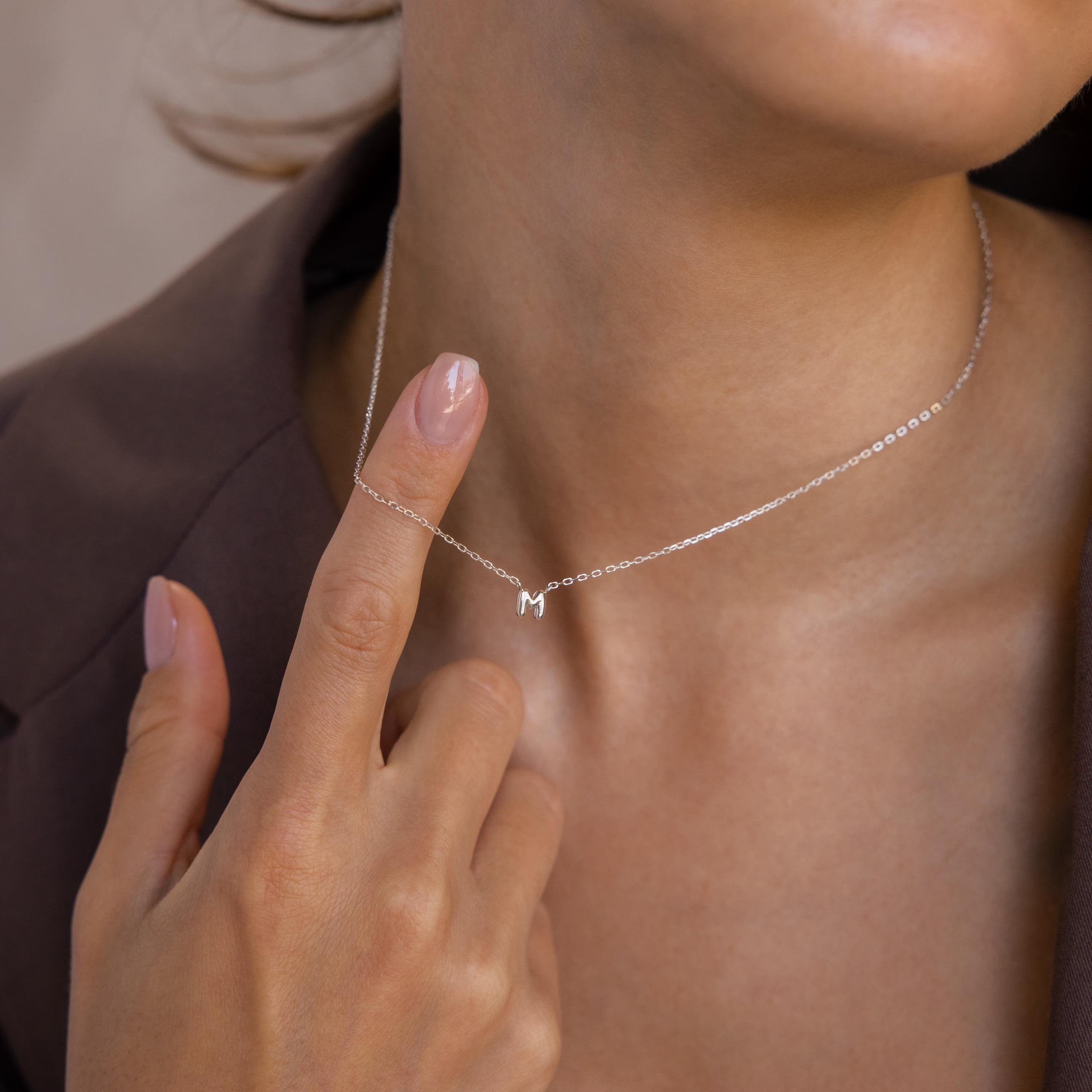Model wears a Silver bubble initial necklace in the letter M.