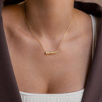 Model wears a gold bubble Bianca name necklace