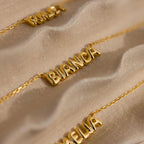 Close up of Bianca gold bubble name necklace, with Riley and Amelia name necklace on the sides