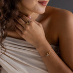Woman models the Interlocking Circles Necklace and Bracelet Set—featuring gold and silver mixed metals—with a matching interlocking circles ring, styled with a soft beige off-shoulder top.
