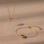 Interlocking Opal Inlay Necklace and Bracelet Set, elegantly displayed on a beige surface with soft shadows.