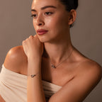 A woman models an off-shoulder top, highlighting the Interlocking Opal Inlay Necklace and Bracelet Set in Silver against a neutral background.
