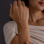 Woman wears the Heart Station Necklace & Bracelet Set in Sterling Silver, hand resting on chest against a neutral background.