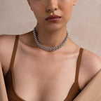A woman wears a brown ribbed tank top with exposed shoulders, styled with the Chunky Link Mesh Necklace for a bold statement look.