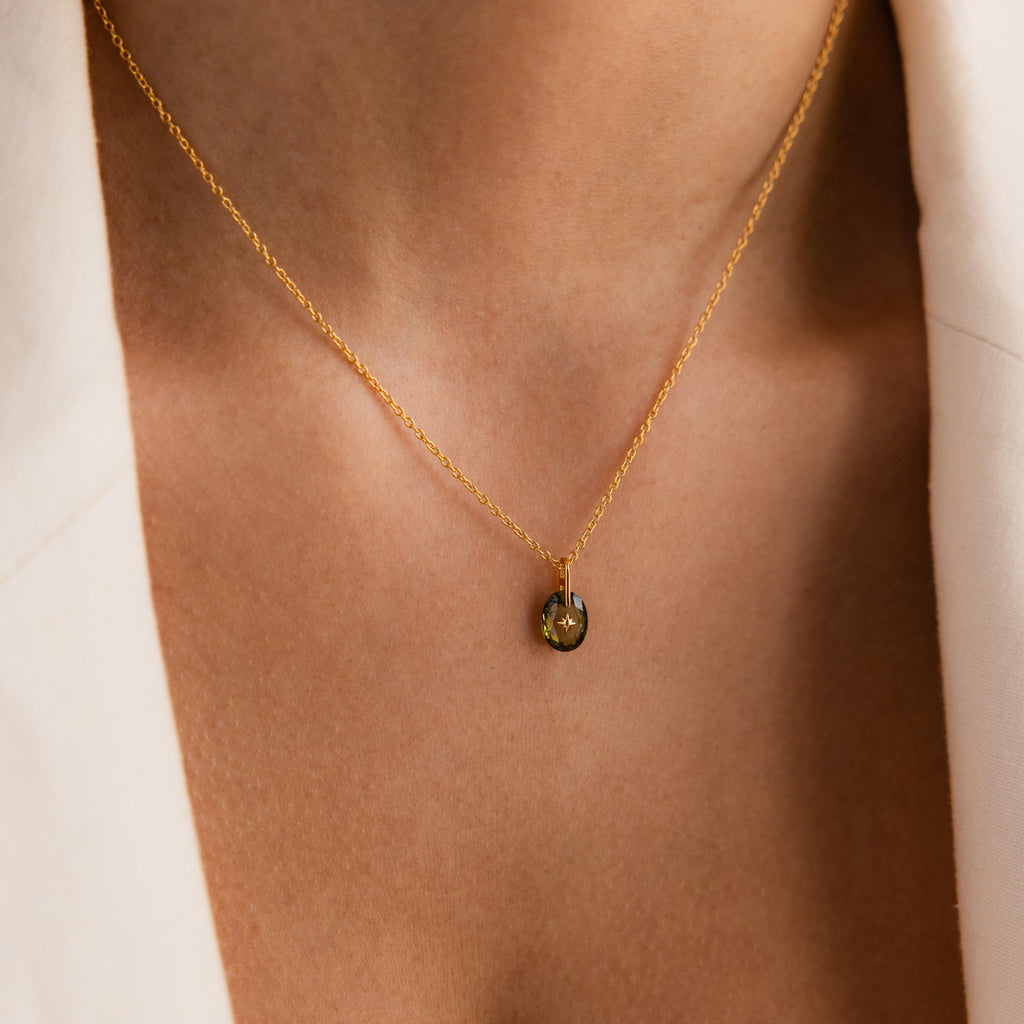 Close-up of model wearing a Gold North Star Birthstone Necklace with a Green Peridot Gemstone.