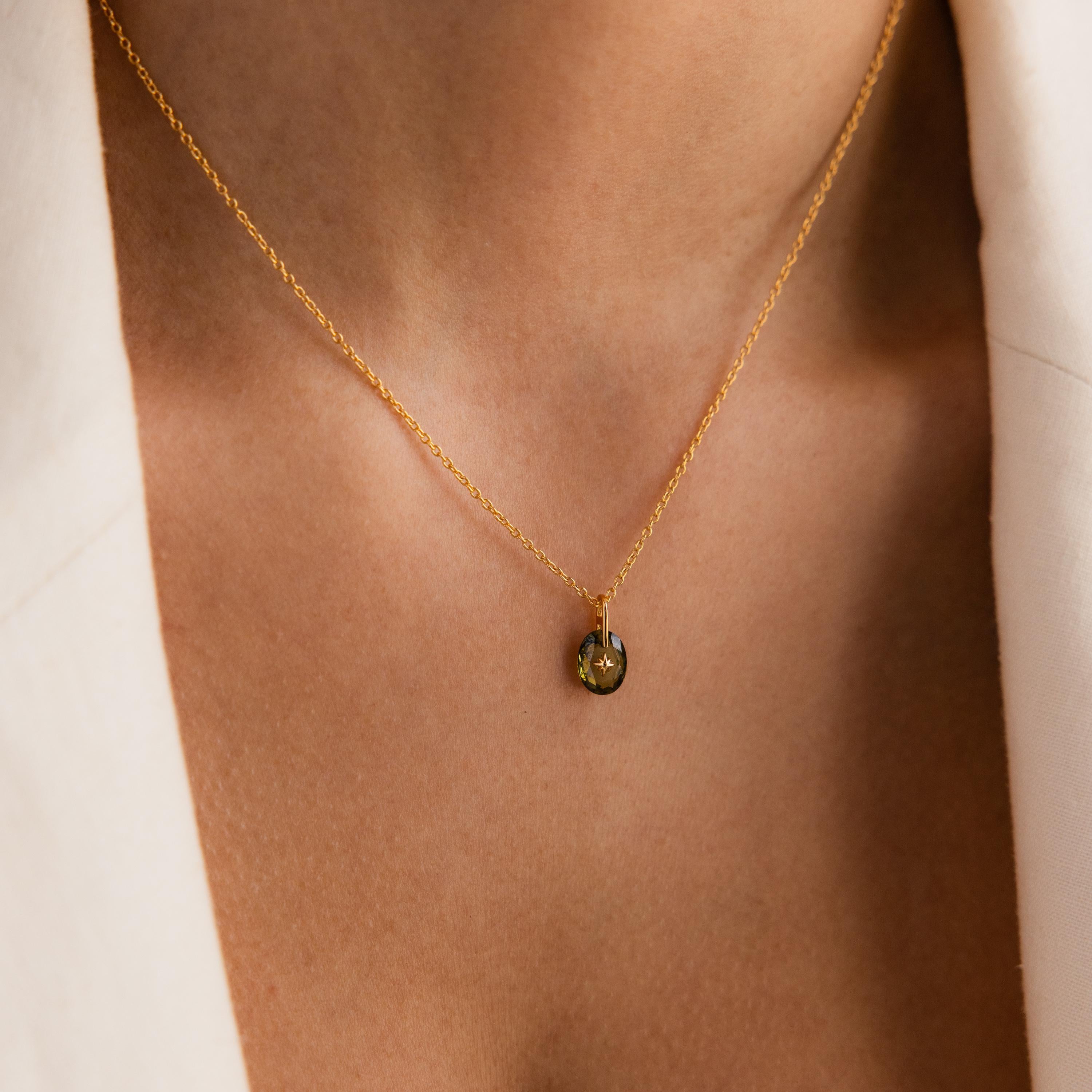 Close-up of model wearing a Gold North Star Birthstone Necklace with a Green Peridot Gemstone.