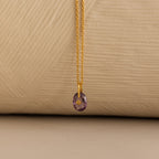 Close up of a Gold North Star Birthstone Necklace with a Purple Amethyst Gemstone.