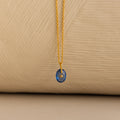 Close up of a Gold North Star Birthstone Necklace with a Blue Aquamarine Gemstone.