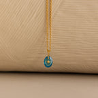 Close up of a Gold North Star Birthstone Necklace with a Blue Turquoise Zircon Gemstone.