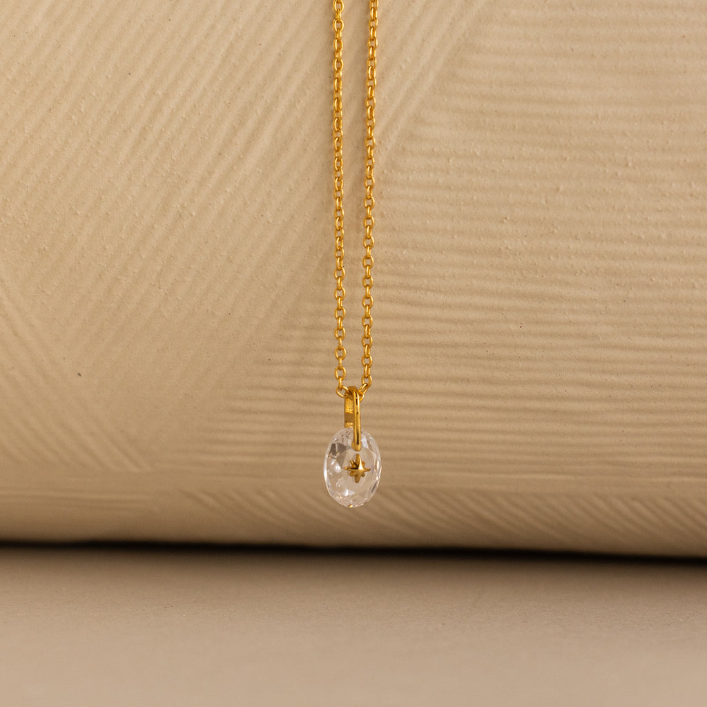 Close up of a Gold North Star Birthstone Necklace with a Clear Diamond Gemstone.