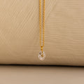 Close up of a Gold North Star Birthstone Necklace with a Clear Diamond Gemstone.