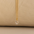 Close up of a Gold North Star Birthstone Necklace with a Clear Diamond Gemstone.