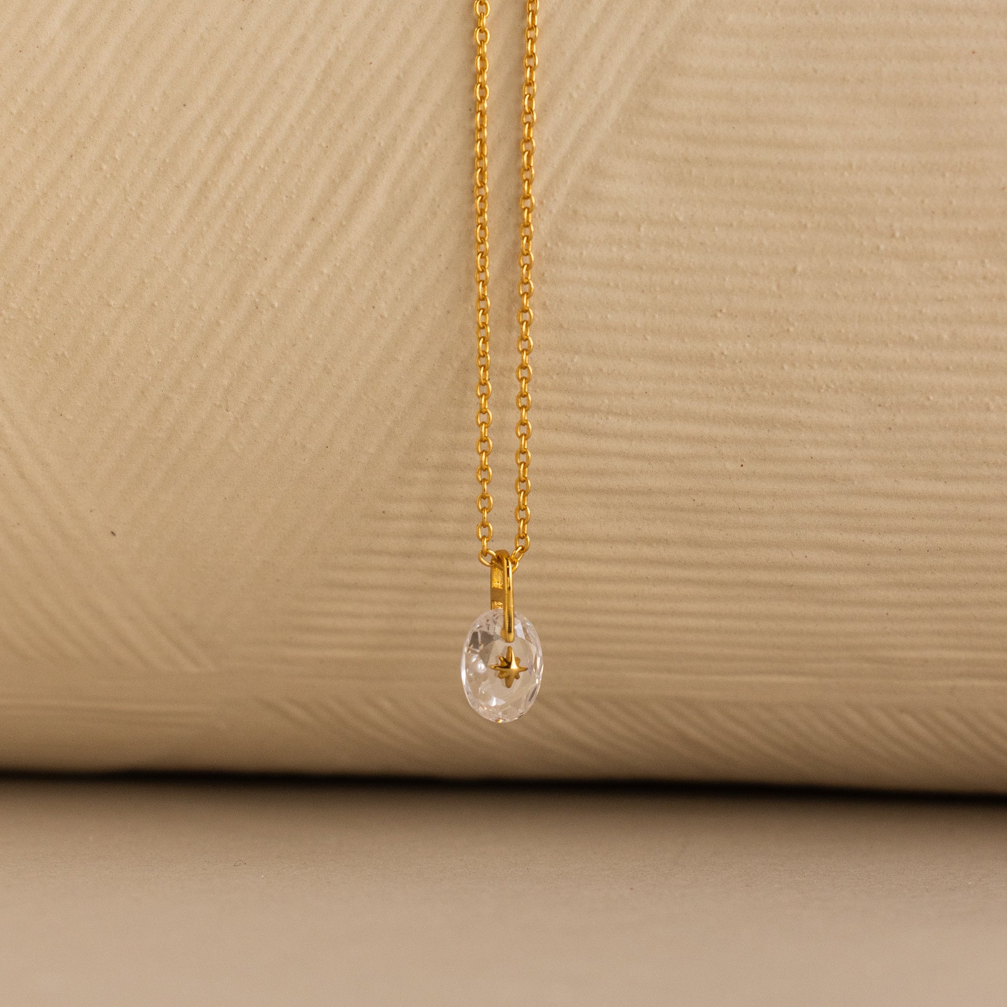 Close up of a Gold North Star Birthstone Necklace with a Clear Diamond Gemstone.