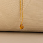 Close up of a Gold North Star Birthstone Necklace with a Yellow Topaz Gemstone.