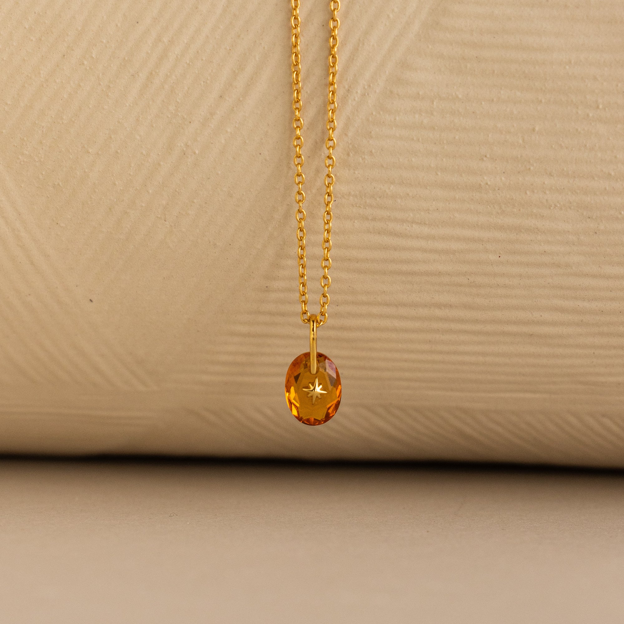 Close up of a Gold North Star Birthstone Necklace with a Yellow Topaz Gemstone.
