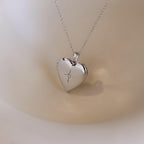 A silver heart-shaped locket with a north star CZ diamond in the center on a delicate cable chain.