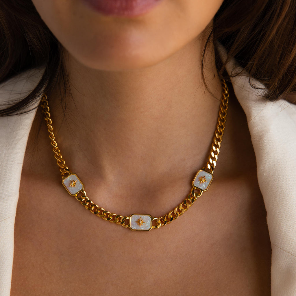Model wearing a Gold Curb Chain Necklace with three North Star Opal Charms.