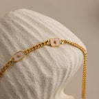 Close-up of Gold North Star Opal Necklace draped over a textured cream vase.