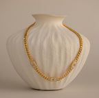 Gold North Star Opal Necklace displayed on a textured cream vase.