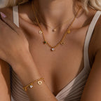 Model wearing layered gold necklaces and matching heart charm bracelet, featuring multi-heart pendants.