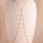 Full view of the 18k gold Diamond Station Body Chain displayed on a textured neutral-toned bust, showcasing its Y-shape silhouette and evenly spaced diamonds