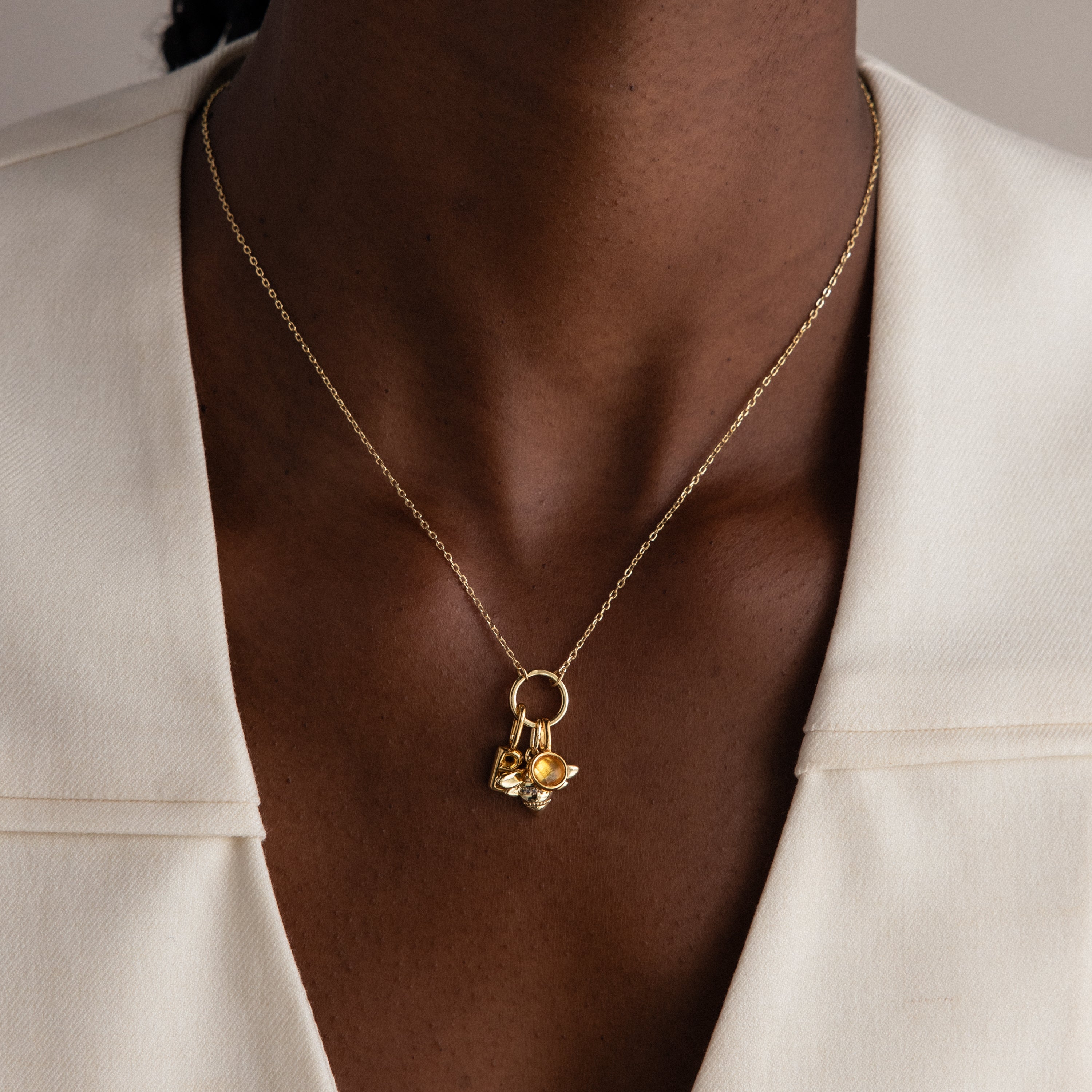 A modern essential, the Large Rolo Clasp Necklace features gold links and a bold chain detail—perfect for layering over a white blazer.