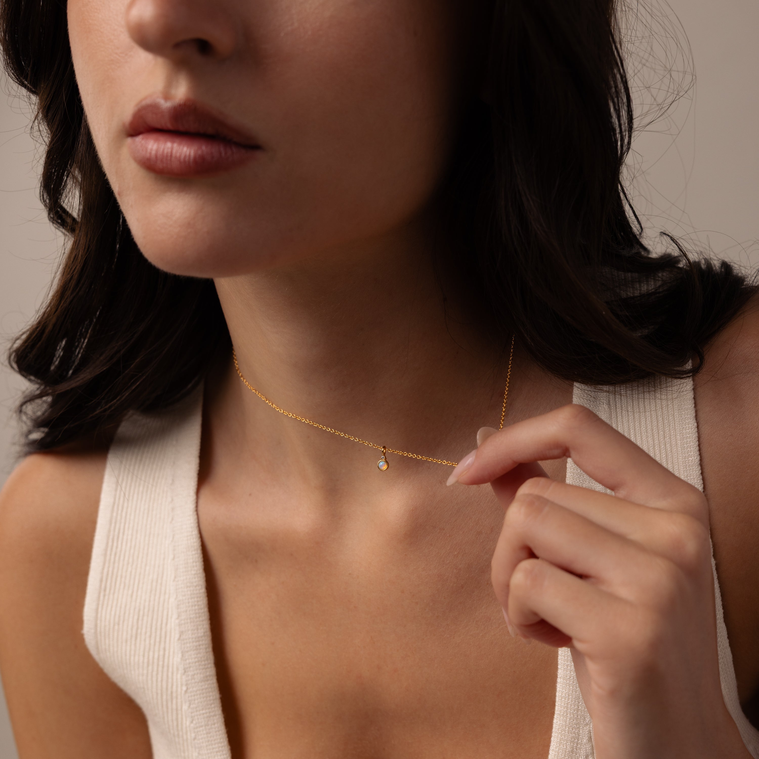 Model wearing our Opal Diamond Necklace in Gold, holding the chain