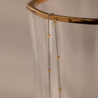 The Mixed Metal Beaded Necklace features a silver satellite chain with small gold beads, making it perfect for layering and adding an elegant touch to any outfit.