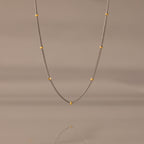 The Mixed Metal Beaded Necklace features a silver satellite chain with small gold beads evenly spaced—ideal for layering.
