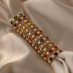 The Birthstone & Pearl Lace Ring features vibrant stones and pearls on white lace, accented with a delicate gold band for an elegant touch.