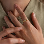 Model wearing a dainty gold bubble letter ring with the name "ROMY".