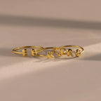 The Duo Bubble Initial Ring in gold showcases the letters E, K, and R on a neutral surface with soft shadows—ideal personalized jewelry for your ring stack.