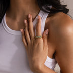 A woman wearing a white tank top displays the Duo Aquamarine Tennis Linked Ring Set on her finger, with her hand gently resting on her chest.