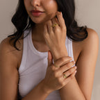 Woman in white tank top showcases the Duo Birthstone Tennis Linked Ring Set and gold rings on her fingers against a neutral background.