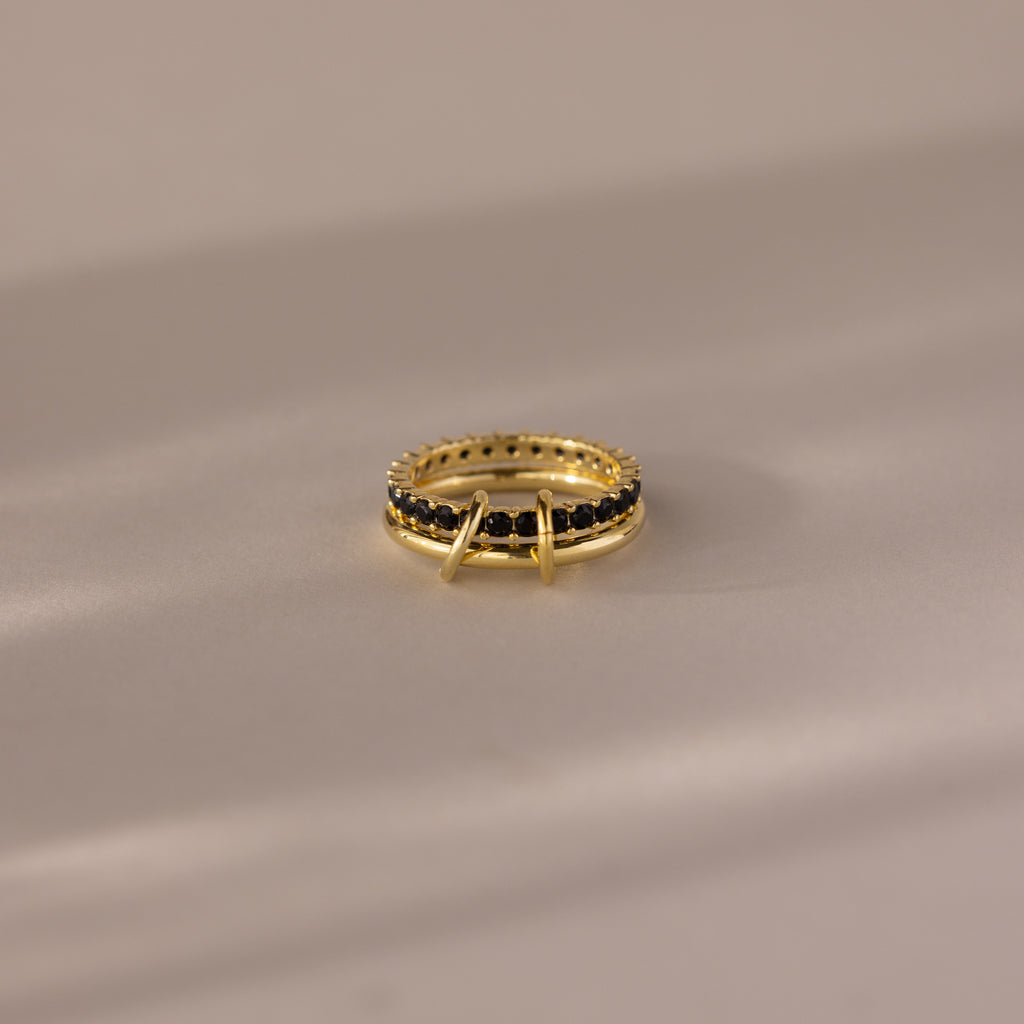 The Duo Birthstone Tennis Linked Ring Set in Onyx is displayed on a light, reflective surface.