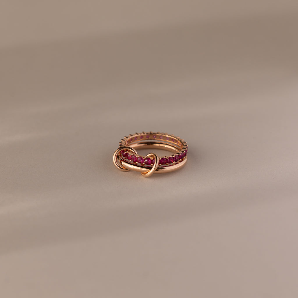 Duo Ruby Tennis Linked Ring Set—features minimalist gold bands linked and adorned with pink gemstones, creating an elegant heart-inspired design perfect as a birthstone ring for any occasion.