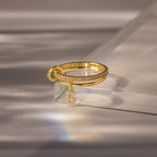 Linked Initial Diamond Ring Set with pavé initial charm and small diamonds, featuring a dangling letter B, elegantly displayed on a reflective surface.