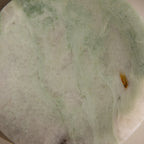 A close-up of the Green Marble Jewelry Dish, featuring a smooth pale green and white surface with subtle brown and yellow patches, perfect as a stylish jewelry holder.