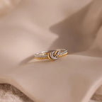 The Mixed Metal Knot Ring, expertly crafted with twisted gold and silver, is beautifully showcased on soft beige fabric—a meaningful gift that celebrates unity and connection.
