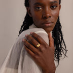 A woman wears the Bow Pearl Ring on her finger, positioned near her face.