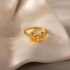 The Bow Pearl Ring rests elegantly on a ceramic surface.
