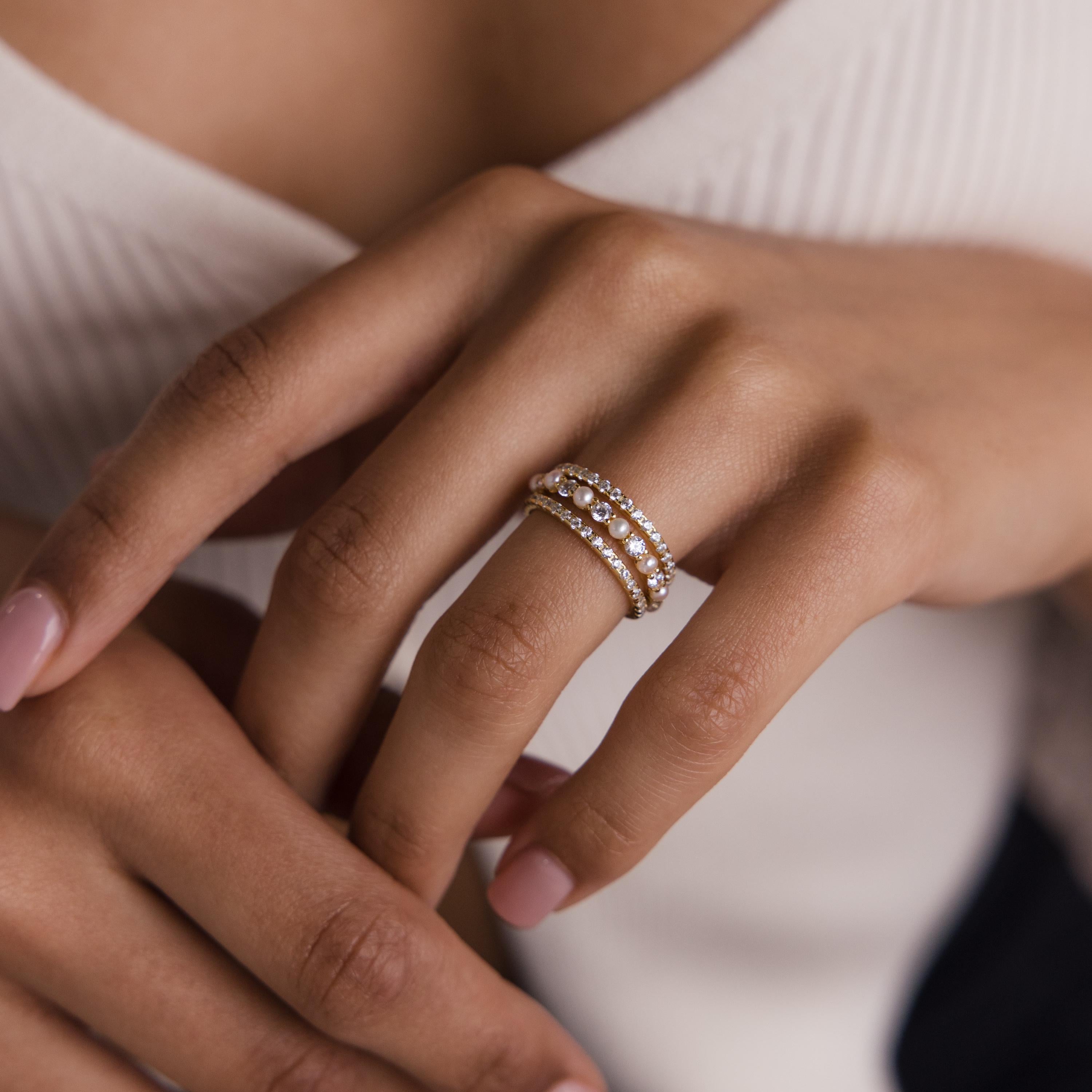 Close-up of a woman's hand with light pink nails wearing the Diamond Eternity Ring Set on her ring finger.