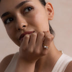 Model wearing the Pearl Diamond Ring on her finger, styled with a natural makeup look and light-colored top, showcasing the ring’s refined design.