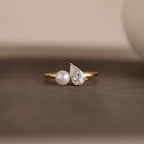 Our Pearl Diamond Ring against a neutral background, focusing on the pearl and diamond setting on the slim gold band.